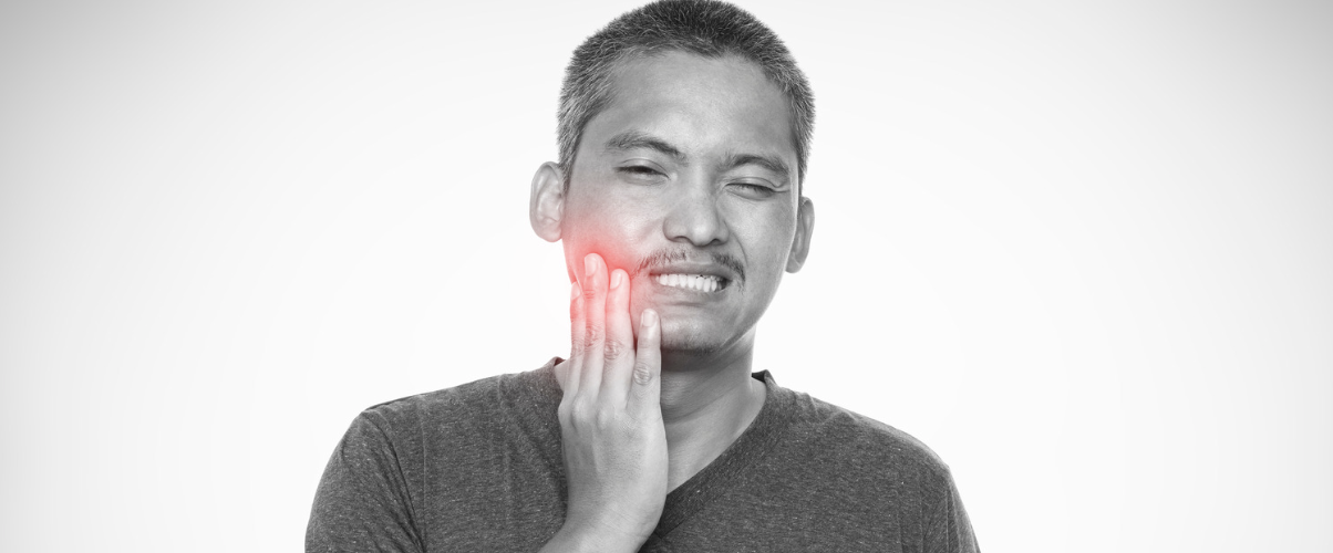 Person holding their face due to TMJ Pain