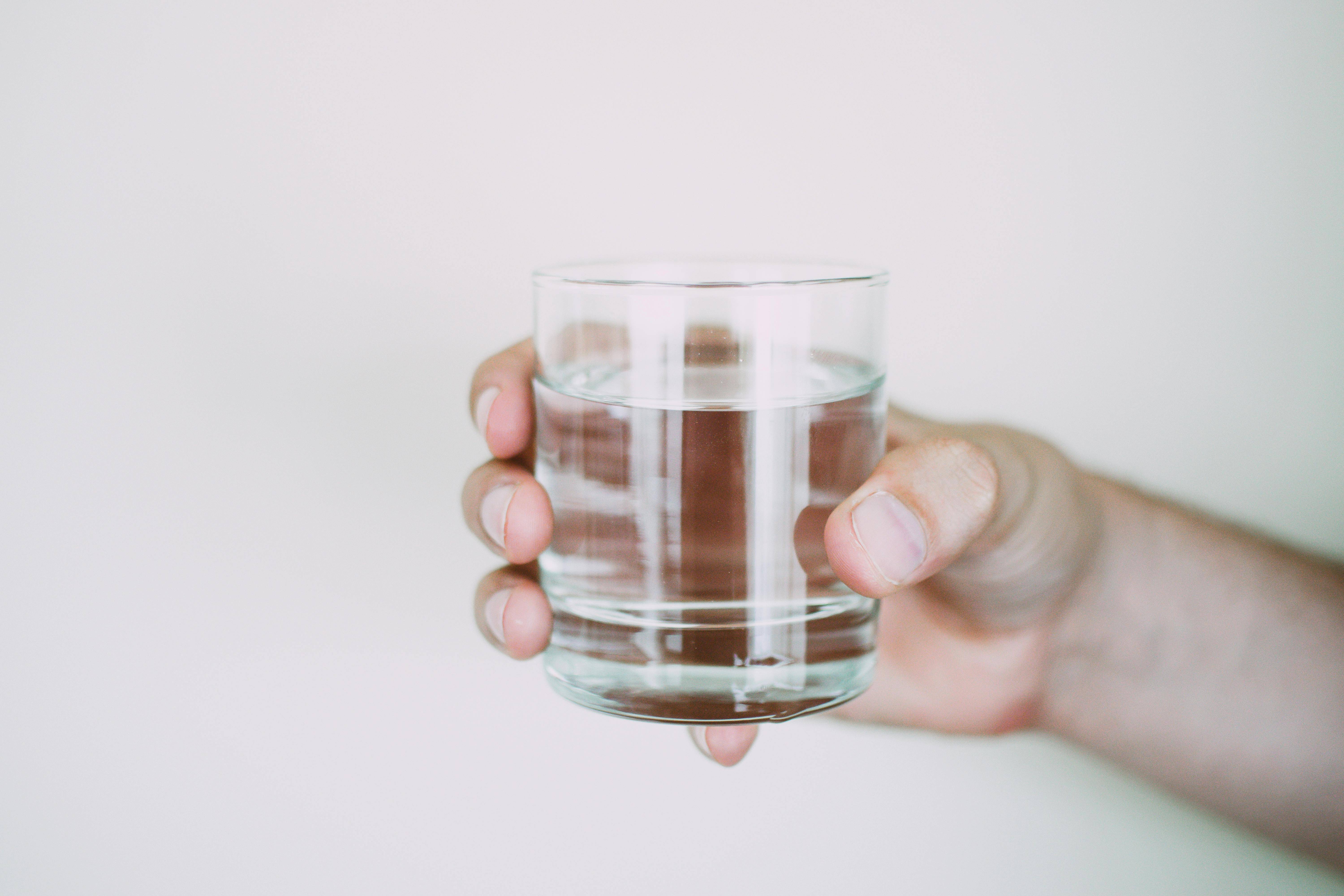 A person holding a glass of water