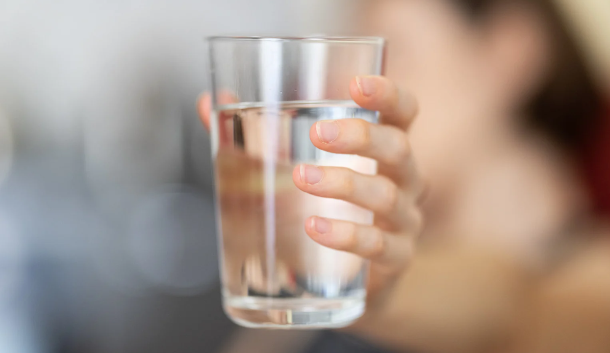 a person holding a glass of water